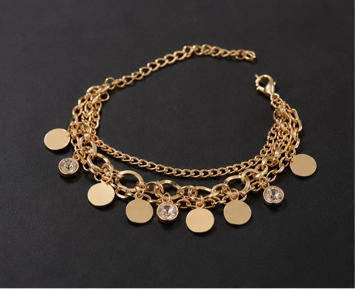 Flat, polished gold-tone circular discs charm bracelet
