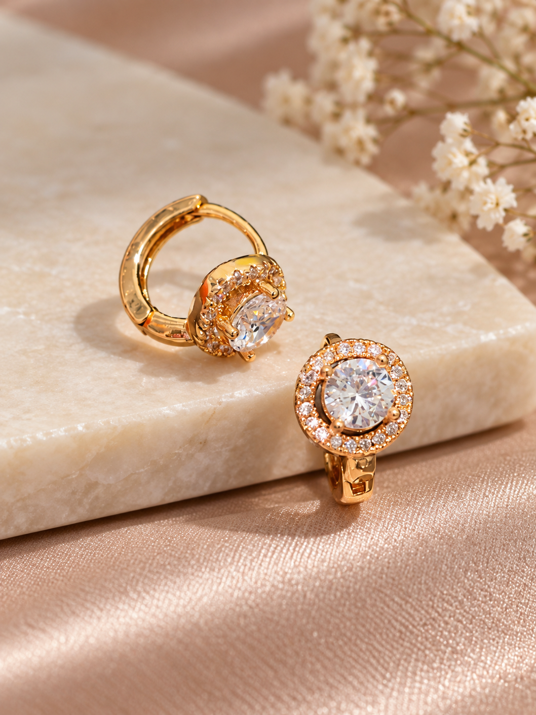 A pair of elegant round halo cubic zirconia huggie hoop earrings