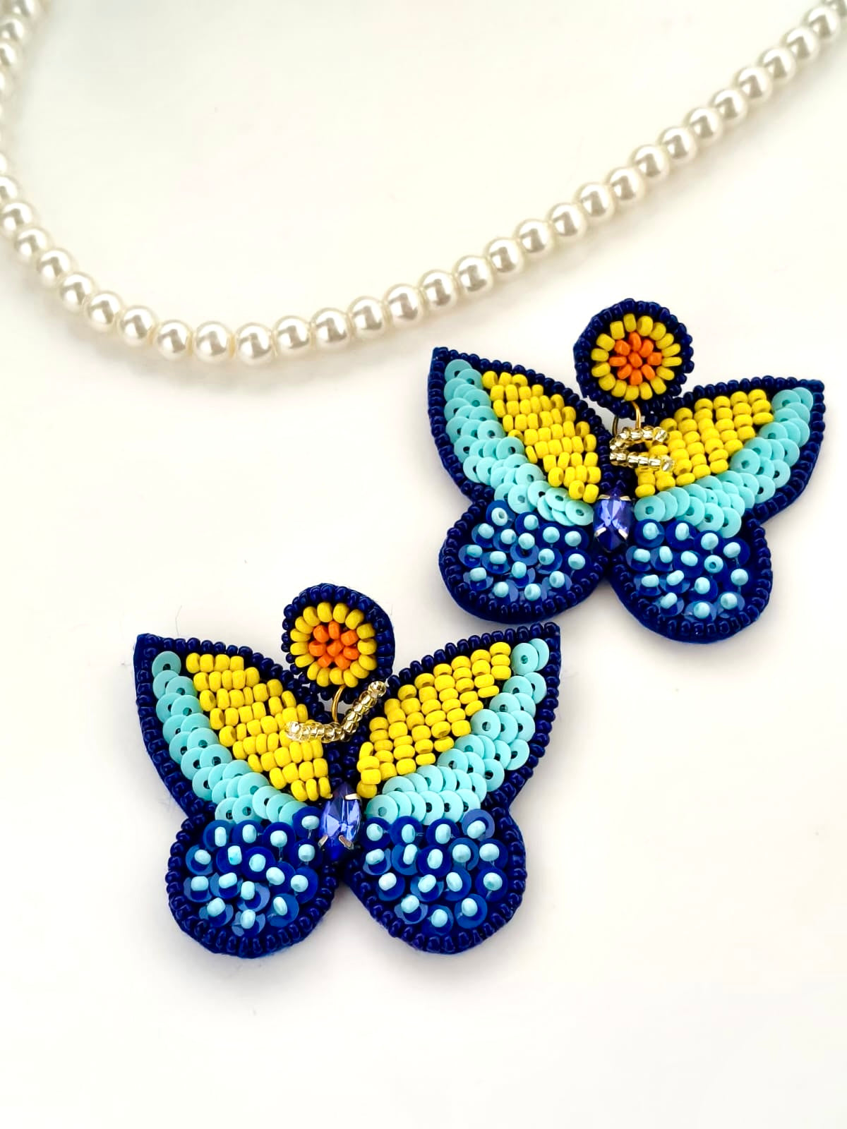 Handmade multi-textured beaded butterfly statement earrings.